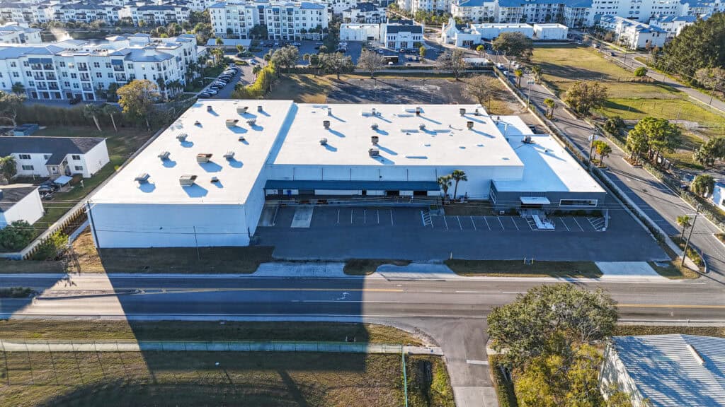 Aerial view of Lithium Battery Company's new 60,000 square foot automated manufacturing facility in Tampa, Florida, featuring modern architecture with solar panels and loading bays